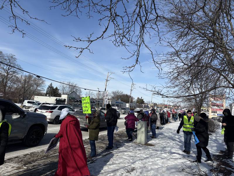 Protesters hold signs during a protest in McHenry Feb. 1, 2026.