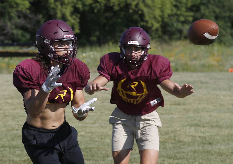 Richmond-Burton’s Nate Komar catches the ball as Daniel Kalinowski breaks to the ball during summer football practice Thursday, July 14, 2022, at Richmond-Burton High School in Richmond.