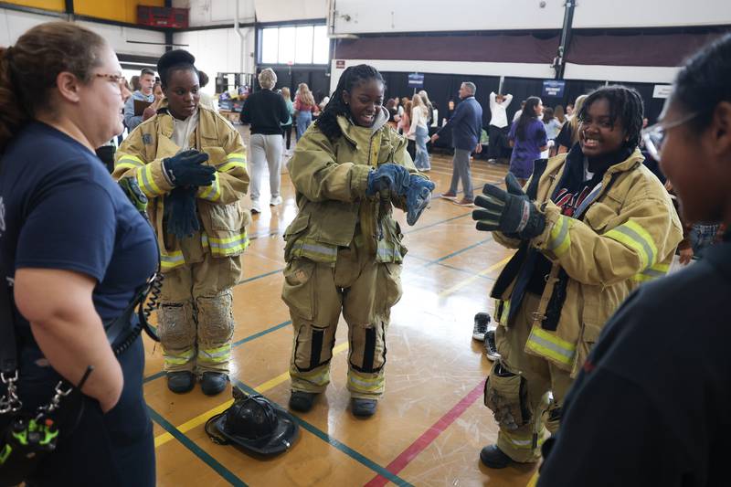 Students are timed putting on fire gear at the Morris Fire Department table at the Grundy Area Vocational Center 8th grade Career Fair at Morris High School on Tuesday, Oct. 29, 2024 in Morris