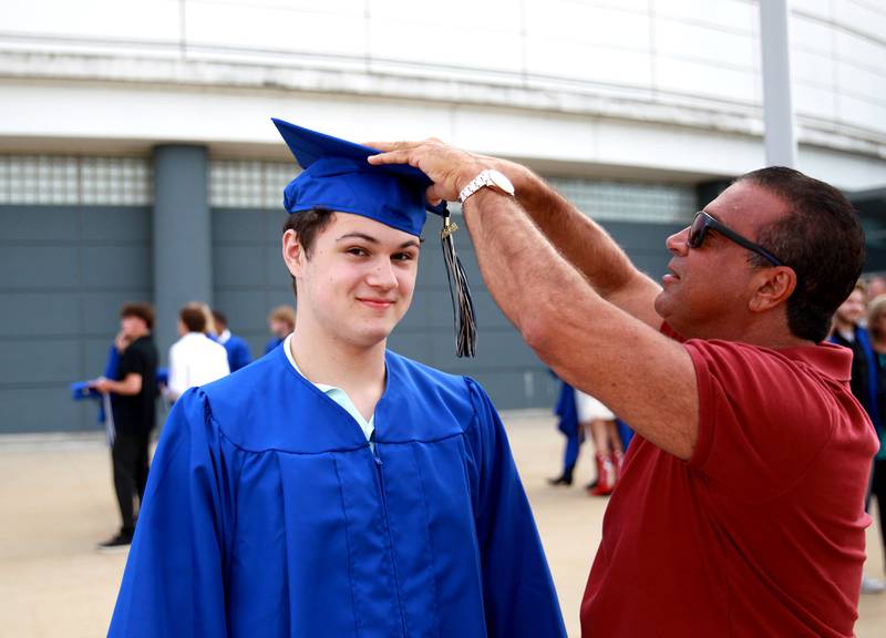 St. Charles North graduate Tony Buttitta has his hat fixed by his dad, Tony, before the school’s commencement ceremony at Northern Illinois University in DeKalb on Monday, May 20, 2024.