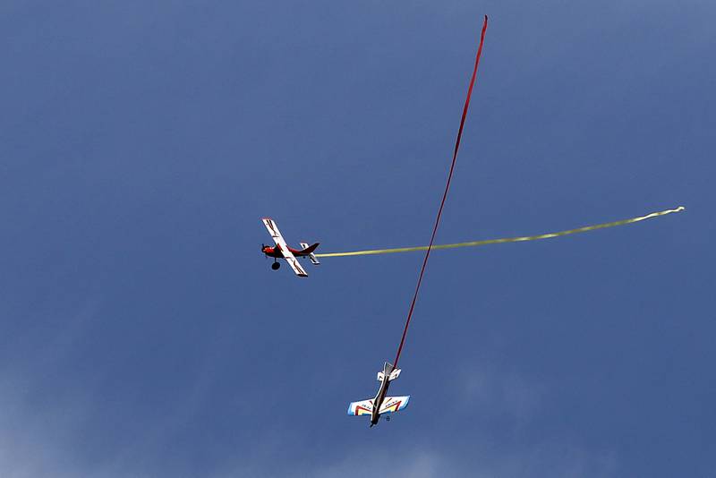 Two radio-controlled planes have a streamer dogfight on Thursday, Aug. 8, 2024, near Hebron.