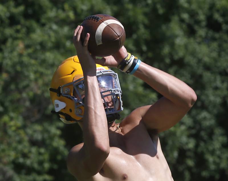 Kevin True makes a catch during football practice Monday, June 20, 2022, at Jacobs High School in Algonquin.