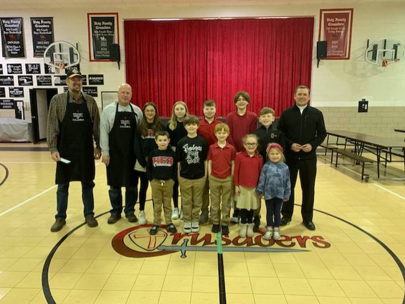 The Oglesby Knights of Columbus raised $1,500 for Holy Family School through a March 10 fish fry at the KC Hall. Grand Knight Tom Daley (from left, holding the check), council officer and cook Dave Zebron pose Friday, March 24, 2023, in the school gymnasium with the Very Rev. Paul Carlson (right), pastor of Holy Family Church, and with a student from every grade level at Holy Family School.