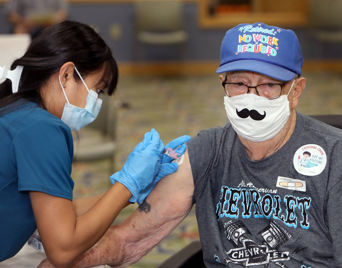 Timbers of Shorewood resident Joe Fiday receives the COVID-19 booster vaccine and flu vaccine from Saint Francis College of Nursing student Lorimel Edquid during a vaccine clinic held at Timbers of Shorewood Friday, October 8, 2021, in Shorewood, Ill.