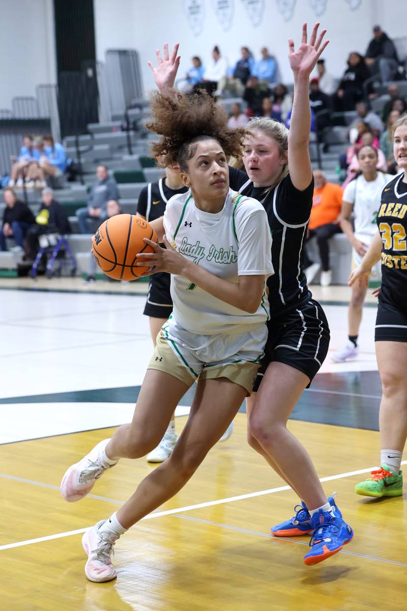 Bishop McNamara's Trinitee Thompson drives to the basket against Reed-Custer's Morgan Toler during Bishop McNamara's 60-36 victory over Reed-Custer in the IHSA Class 2A Bishop McNamara Regional semifinals on Monday, Feb. 16, 2026.