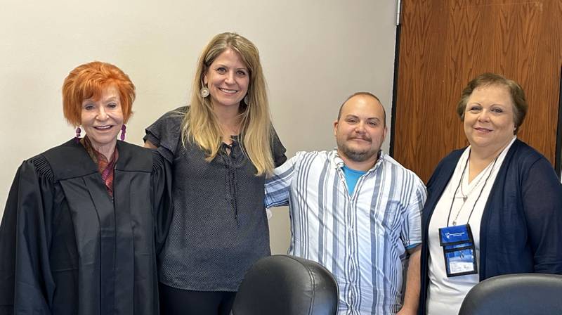 (From left) 13th Judicial District Judge Cynthia Raccuglia, Laura Nash, Riley Kozak and Sally M Van Cura pose for a photo after the swearing-in of two new volunteers and the new executive director.