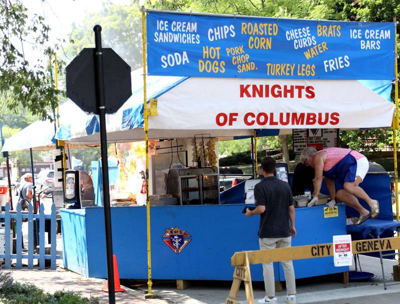 Workers escape after a brief fire erupted in the cooking area of the Knights of Columbus tent at Third Street and Campbell on the first day of the 2023 Swedish Days Festival on Wednesday, June 21, 2023. No one was injured.