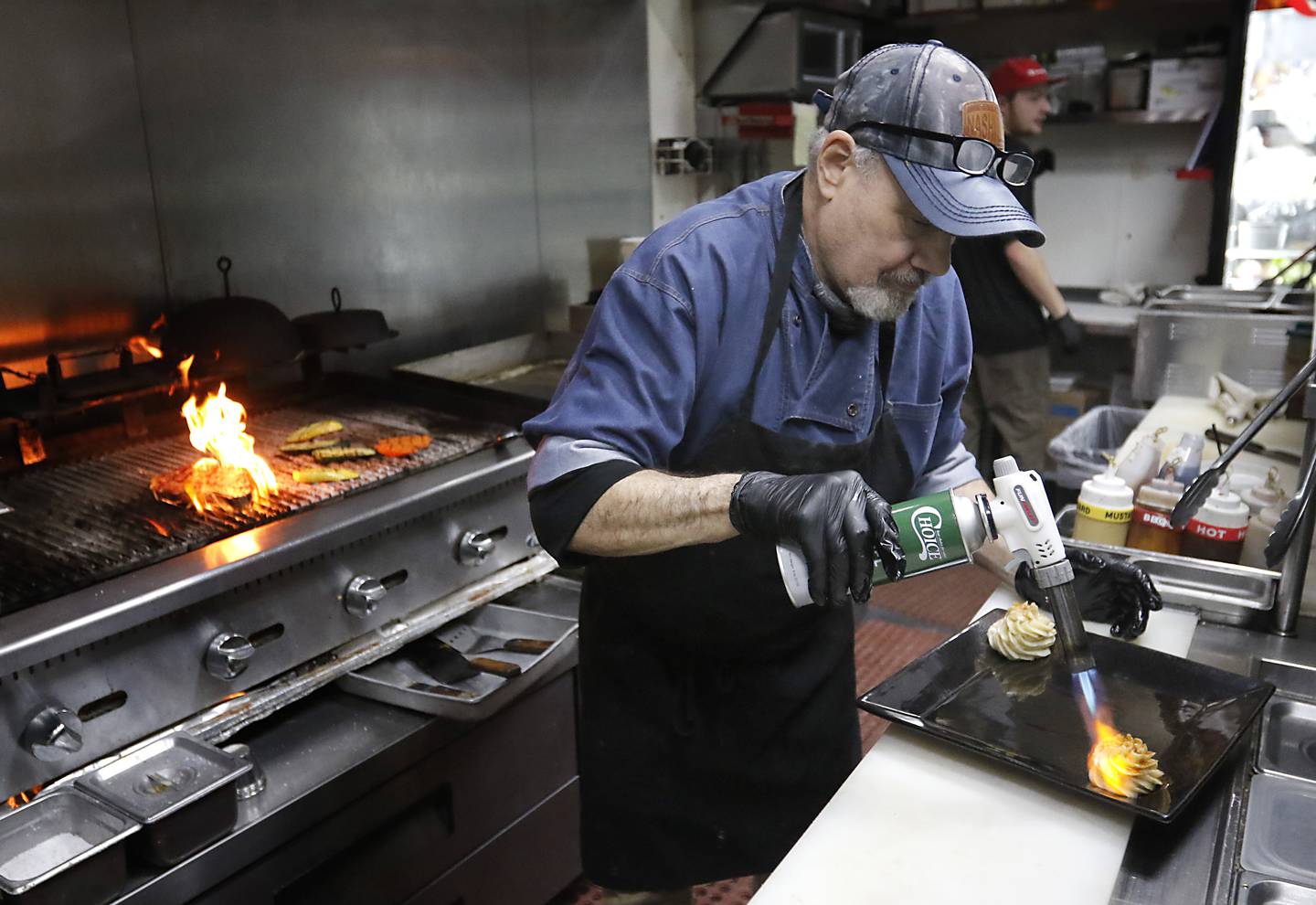 Executive chef Micheal Borlek plates a bone-in-ribeye steak on Tuesday, Jan. 14, 2025, at Addison’s Steakhouse, 335 Front St,,in McHenry,  The restaurant will be moving into the McHenry Country Club in March..