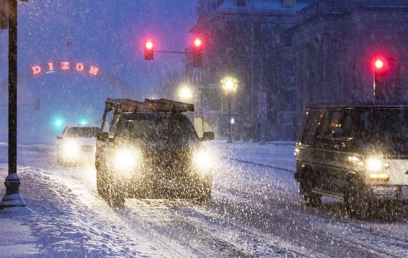 Vehicles drive down Galena Avenue in Dixon Tuesday as a storm covered area towns in a blanket of snow.