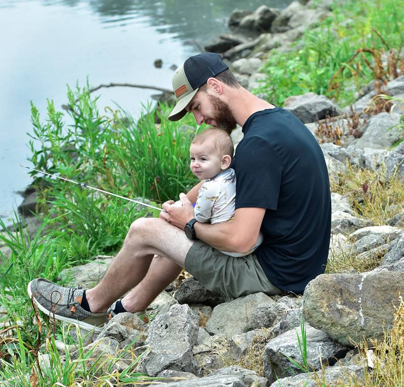 Branden Cartier started out the Father's Day weekend showing his son,  Waylon,  7 months, how to fish at the 19th annual Dick Brown Fishing Derby held at Prophetstown State Park on Saturday, June 14, 2025.