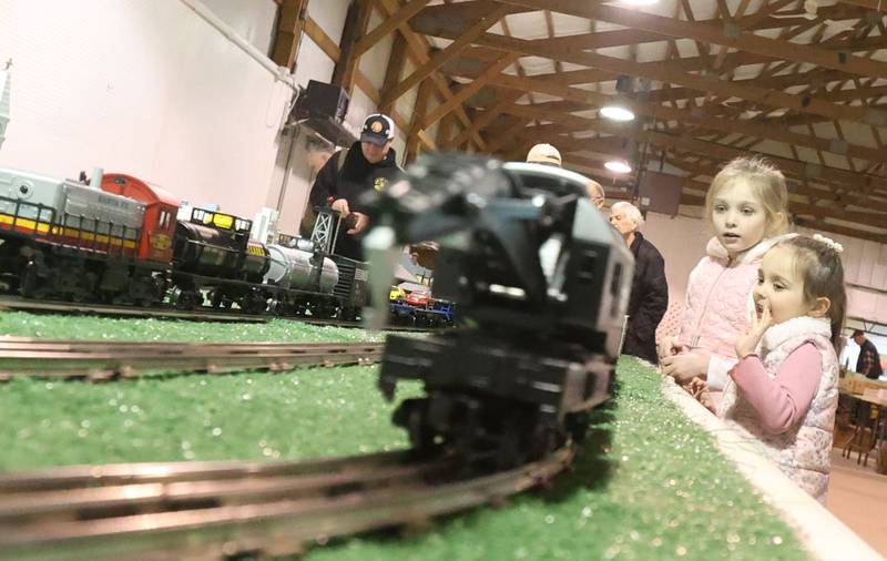 Briella Kemmerer and her sister Chloe, stare at an Lionel O Gauge train set during the Model Train and Toy Show on Saturday, Feb. 14, 2026 at the Bureau County Fairgounds in Princeton.