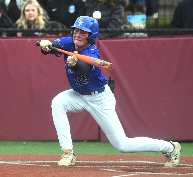 St. Francis' Luc Swiatek tries to lay down a bunt but pops the ball foul during Tuesday’s baseball game against Wheaton Academy in West Chicago.