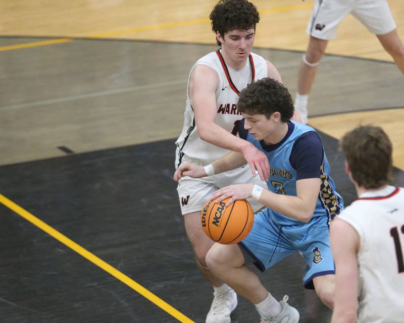 Marquette's Easton Debernardi cuts in the lane as Woodland's Brezdyn Simons defends during the Tri-County Conference Tournament championship on Friday, Jan. 30, 2026 at Putnam County High School.