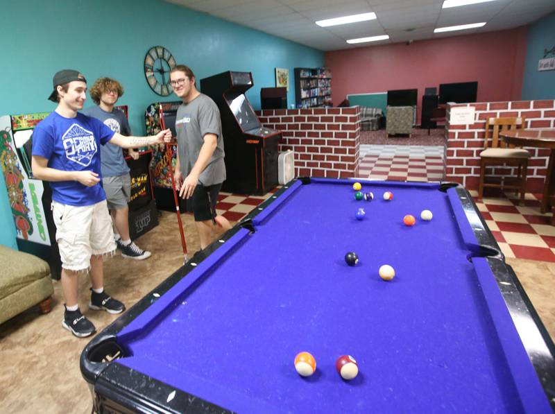 Bradyn Briddick, James Schillaci and his brother Dominic shoots a game of pool at the current Second Story Teen Center above Johnson's Carpet on Wednesday, Aug. 16, 2023 in Princeton.