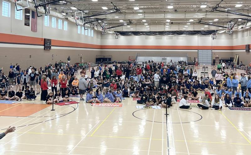 All the teams listen to instructions on the court after the parade of teams Friday, May 10, 2024, during the IHSA State Badminton Finals at DeKalb High School.