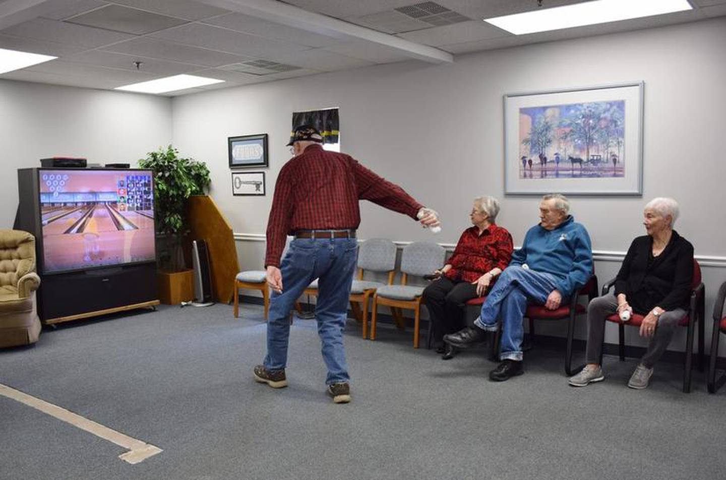 Leon Dettman of Somonauk bowls a strike during a game of Wii bowling at Fox Valley Community Center, 1406 Suydam Road in Sandwich. Dettman and his wife Bobbie visit Fox Valley Older Adult Services at least twice a week for programs, activities and lunch and attend almost all of the day and weekend trips offered.