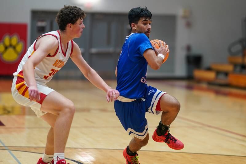 Batavia’s Payton Wolff (34) defends the paint against Marmion's Ali Muhammed Tharwani (5) during a basketball game at Batavia High School on Wednesday, Nov. 27, 2024.