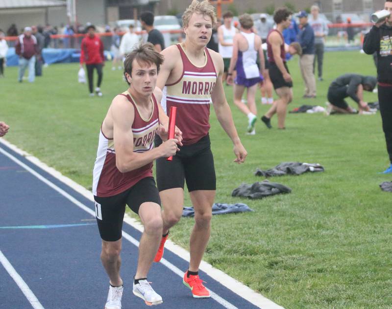 Morris's Everett Swanson grabs the baton from Nikita Hovious in the 4x800 relay race during the Class 2A Sectional meet on Wednesday, May 21, 2025 at Pontiac High School.