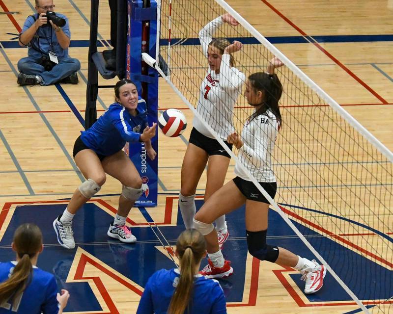 St. Charles North's Haley Burgdorf, left, tries to keep the volley alive after Benet Academy teammates Audrey Asleson, center, and Gabriele Stasys watch after blocking the ball during the 4A sectional championship game on Thursday Nov. 7, 2024, held at West Aurora High School.