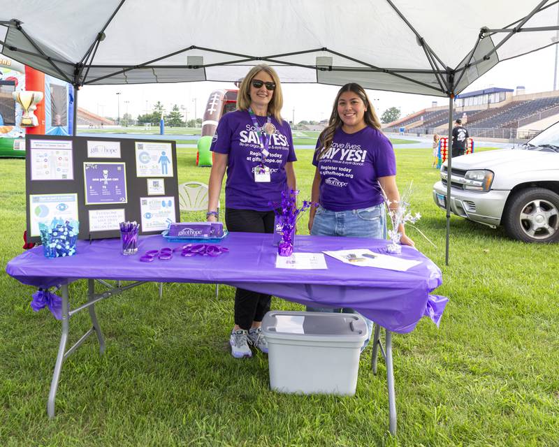 Julie Goodrich (L) and Clarissa Martinez pose at the Gift of Hope table for organ donations at the Joliet Police Department's National Night Out event Tuesday, Aug 5, 2025  in Joliet.