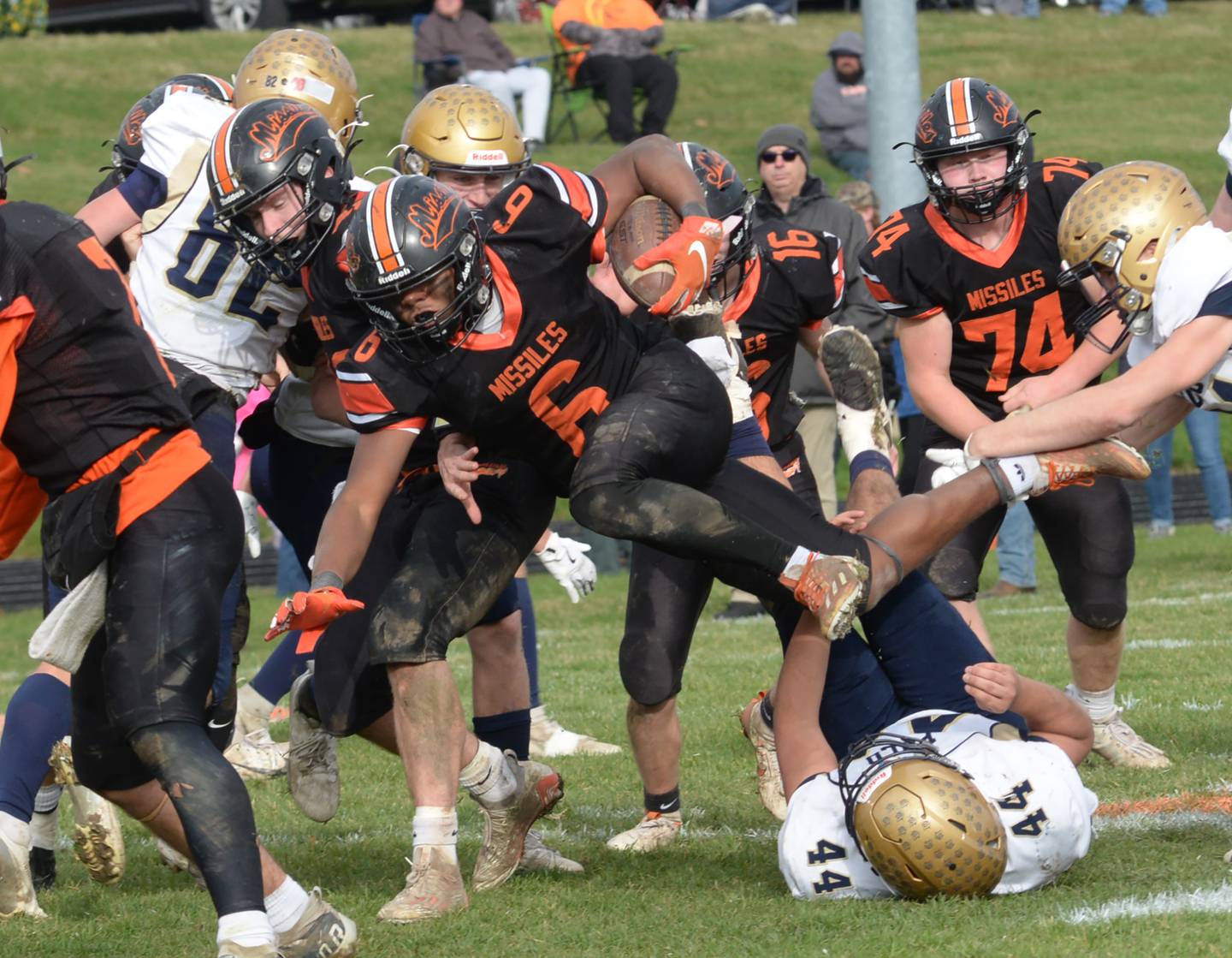 Milledgeville's Micah Toms-Smith (6) dives over defenders during 8-man playoff action against Polo on Saturday, Nov. 16, 2024 at Milledgeville.