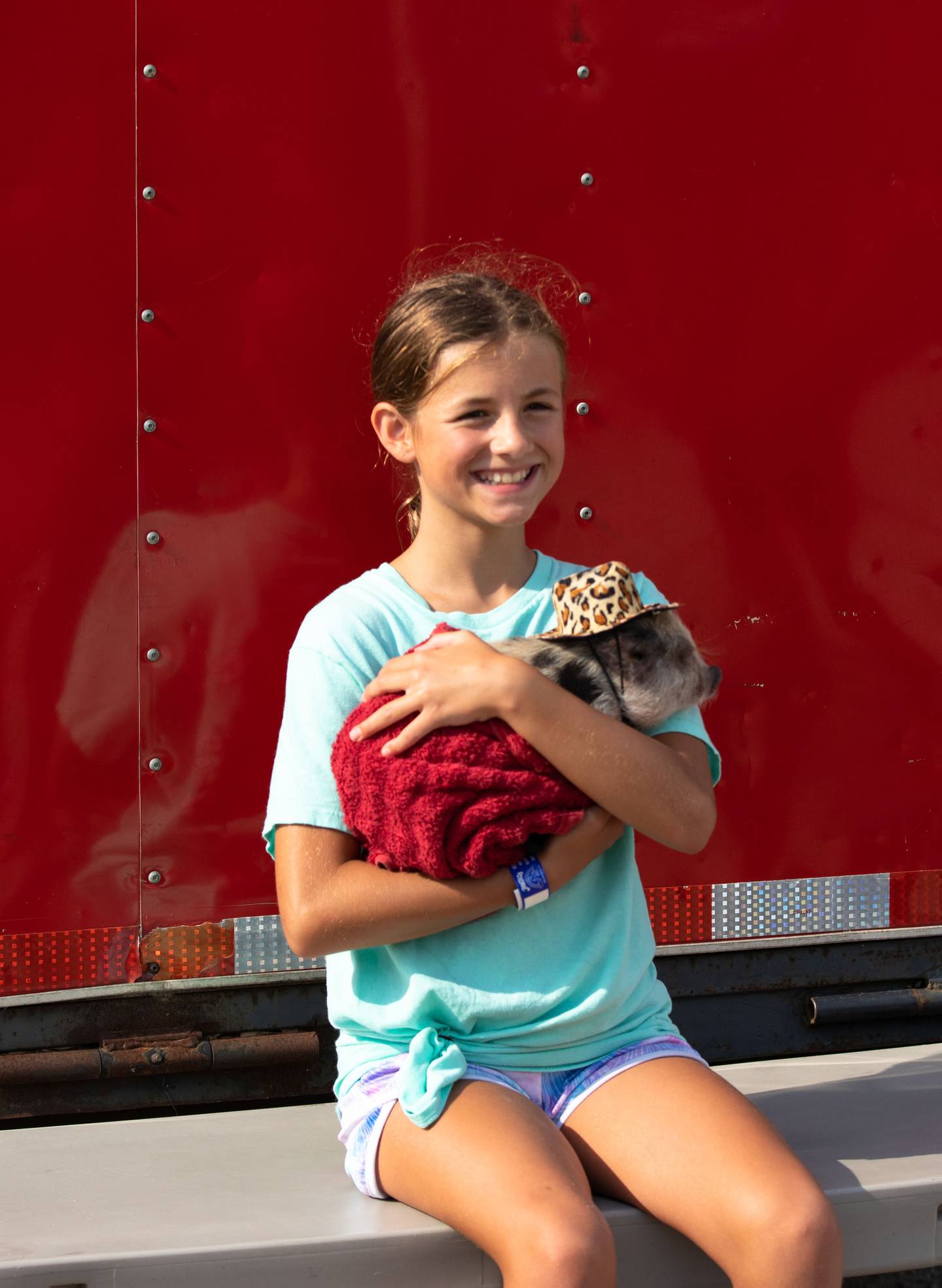 Grace Bachenberg, 11, of South Elgin poses for a picture with a piglet during the last day of the Kane County Fair on Sunday, July 17, 2022.