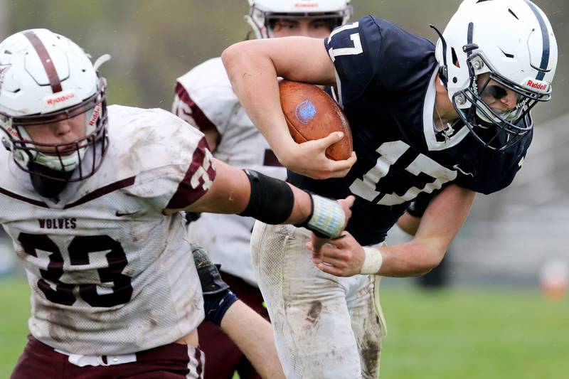 Cary-Grove quarterback Jameson Sheehan evades Prairie RIdge's Carter Evans, front, and Jack Schnoor, back during their football game on Saturday, April 10, 2021 at Cary-Grove High School in Cary. Cary-Grove won 20-7.