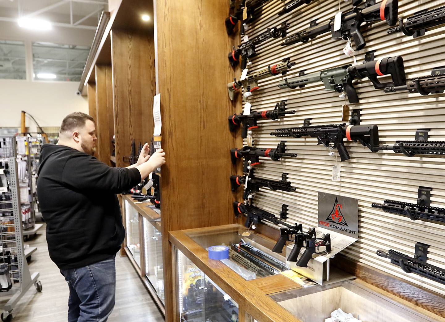 Tyler Duncan, the director of marketing and public relations at Second Amendment Sports, in McHenry, hangs a sign notifying customers that Second Amendment Sports can no longer sell several types of firearms Wednesday Jan. 11, 2023, after a new gun law restricting a number of firearms and attachments and limiting ammunition was signed into law Tuesday night by Gov. JB Pritzker. The bill, along with requiring registration for such guns if already owned and enhancing gun restraining orders, hits at semiautomatic weapons.