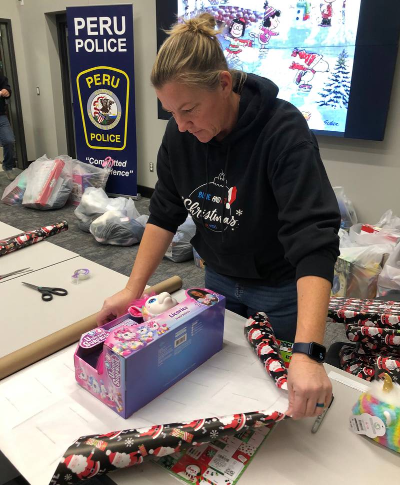 Peru Police Chief Sarah Raymond helps wrap Christmas presents for the Red and Blue Christmas for Kids fundraiser at the police department on Friday, Dec 2, 2022.
