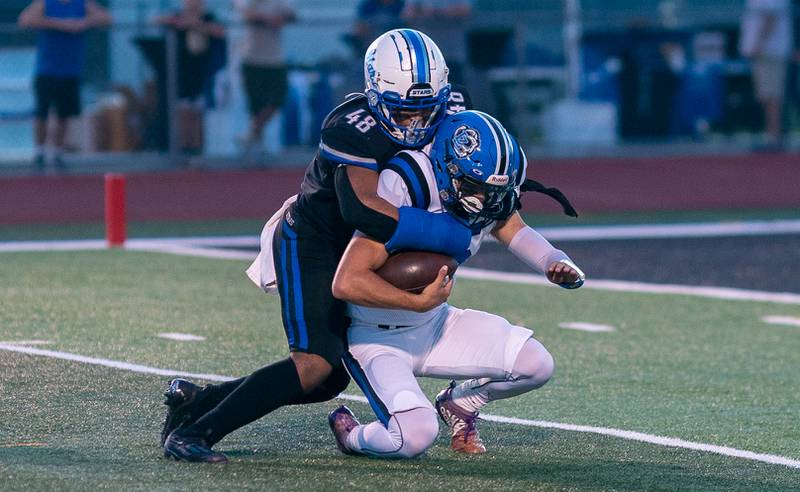 St. Charles North's Angelo Bradley (48) hits Lake Zurich's Ashton Gondeck (15) in the backfield for a loss during a football game at St. Charles North High School on Friday, Sep 2, 2022.