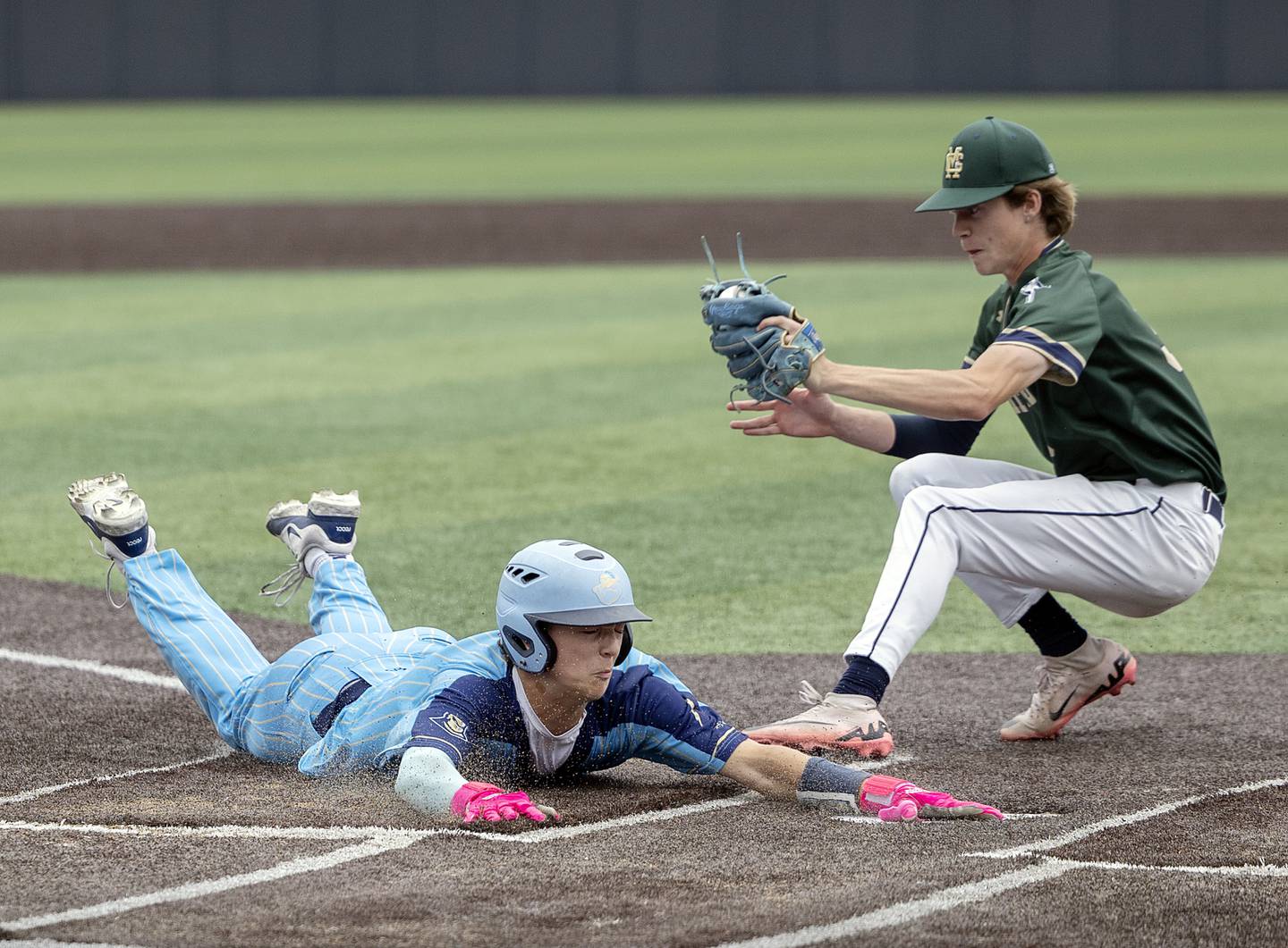 Ottawa Marquette’s Easton Debernardi steals home to tie up the game in the bottom of the seventh as Father McGivney’s Evan Koontz goes for the tag Saturday, June 7, 2025, during the Class 1A state baseball final at Illinois Field in Champaign.