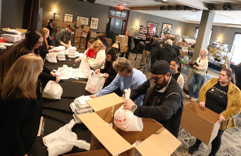 Volunteers help prepare carryouts during the 24th annual Lighted Way Spaghetti dinner on Monday, March 27, 2023 at Uptown in La Salle.