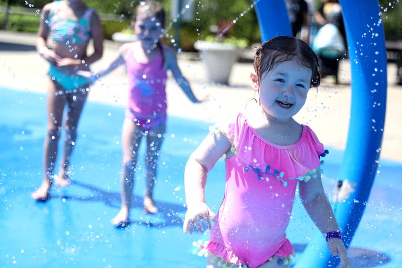 Luna Prendergast, 3, runs through the water closely followed by her sisters Charlotte, 5, and Mia, 7, at the Westmont Park District’s Ty Warner Park splash pad on Tuesday, June 21, 2022. Temperatures were expected to reach the upper 90s.