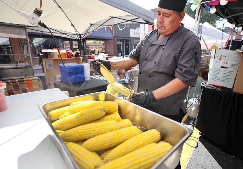 Jesus Munoz , from Nina's Tacos in Sycamore, shucks corn at his booth on Lincoln Highway Friday, Aug. 26, 2022, during Corn Fest in downtown DeKalb