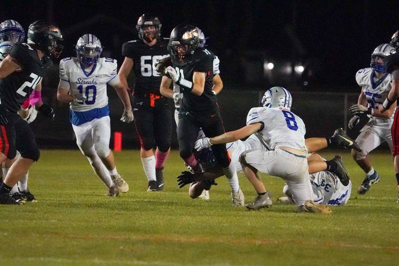Sandwich’s Nick Michalek (11) carries the ball against Woodstock during a football game at Sandwich High School on Friday, Oct. 11, 2024.