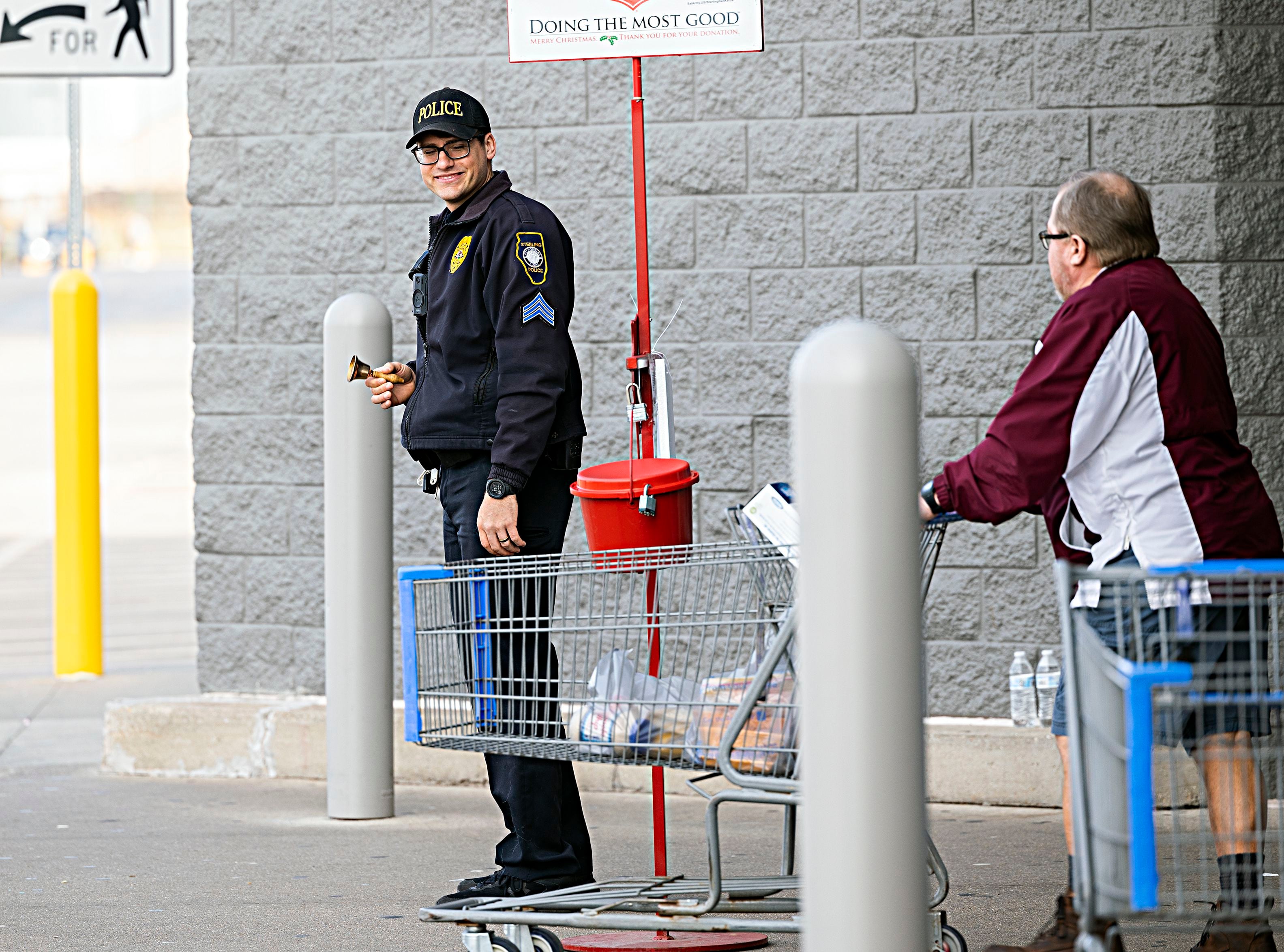 Sterling police officer Anthony Adamson mans the east entrance Friday, Dec. 15, 2023 at Sterling Walmart for the Sterling Fire vs. Police Salvation Army challenge.