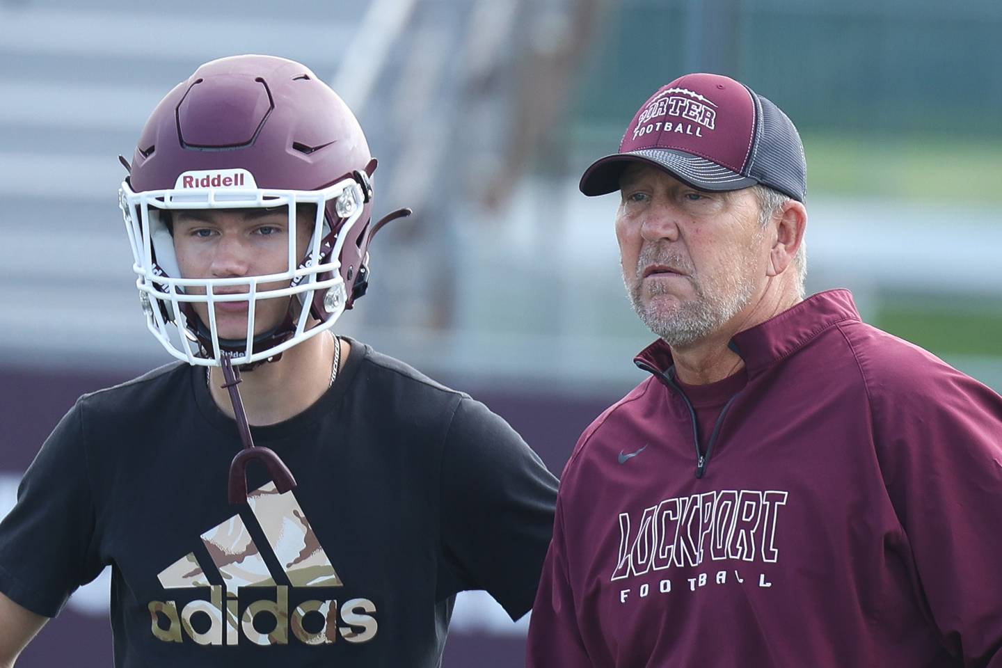 Lockport’s Declan Sojka, left, talks with Brett Kooi, the new offensive and assistant head coach, during the first day of practice on Monday, Aug. 7, 2023 in Lockport.