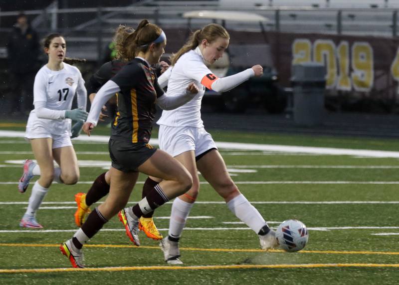 McHenry’s Emerson Gasmann scores a goal as she is defended by Richmond-Burton’s Addison Sell during a non-conference girls soccer match Thursday, March 16, 2023, at Richmond-Burton High.