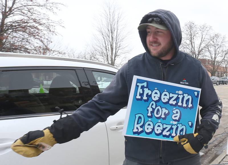 Caid Chemoweth helps collect monetary donations during the 17 annual Freezin’ for a Reezin’ event on Friday, Dec. 5, 2025 outside of the WCMY studios downtown Ottawa. Donations support the Community Food Basket of Ottawa. Fr
