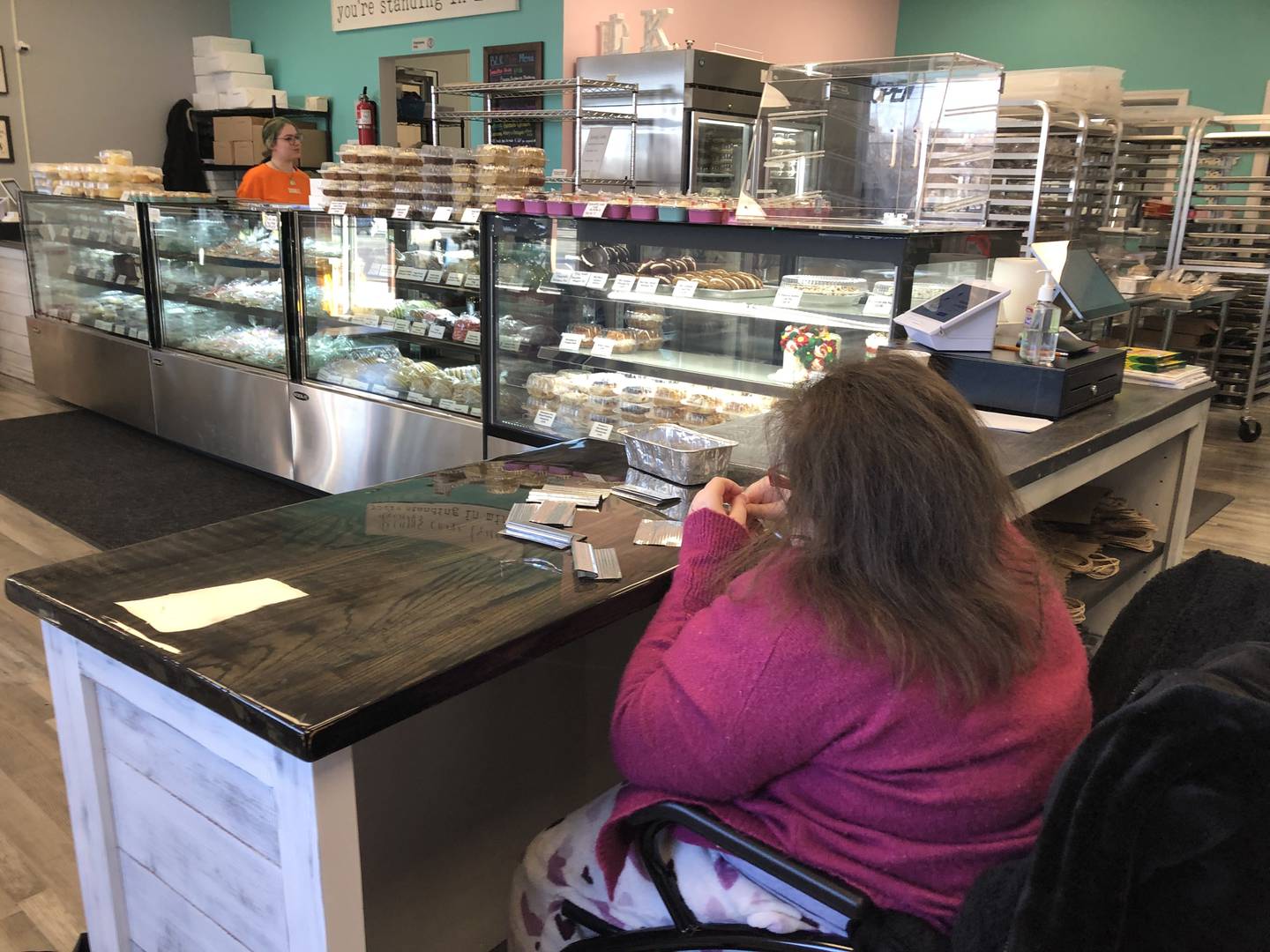 Teagan Haniszewski sits behind the counter at Blessed Little Kitchen in Huntley. The counter has no shelves so Haniszewski can sit closer to the counter.