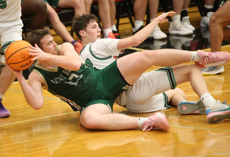 St. Bede's Mason Ross falls on a loose ball with Eureka's Teagan McLaughlin during the 50th annual Colmone Classic on Monday, Dec. 9, 2024 at Hall High School.