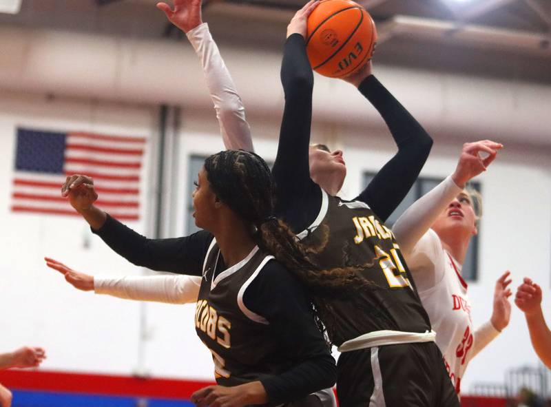 Jacobs’ Olivia Schuster, center, and Bri Ramsey, left, battle others for a rebound in varsity girls basketball on Friday, Dec. 12, 2025, at Dundee-Crown High School in Carpentersville.