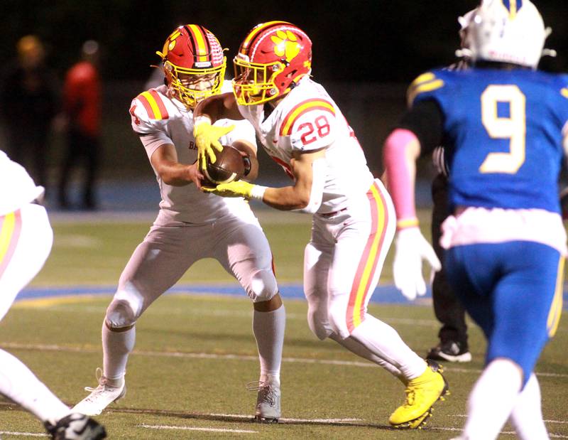 Batavia quarterback Bodi Anderson hands the ball off to Nathan Whitwell during a game on Friday, Sept. 27, 2024 at Wheaton North.