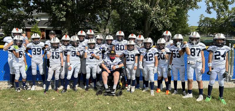 Members of the Downers Grove Panthers 11U football team have embraced Tommy Freedlund, seated, since he joined the team this season. Freelund has Duchenne Muscular Dystrophy but his father wanted him to be part of a brotherhood and know something bigger in life than his disability.