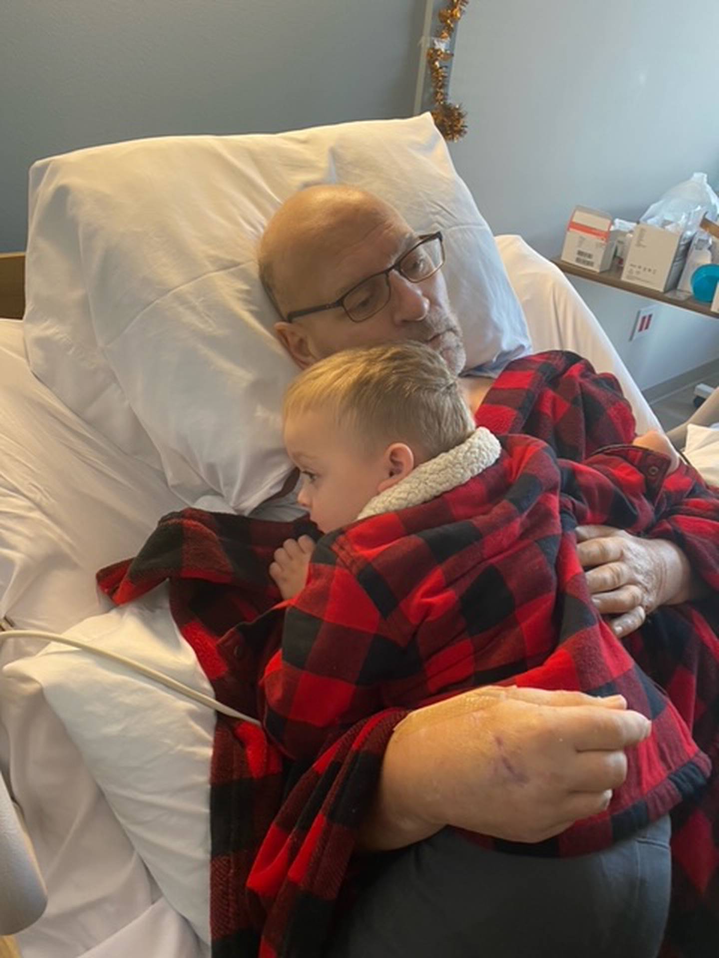 Tim Flannery, 61, of Joliet, hugs his grandson Colin, who recently visited Flannery in the hospital. Flannery was severely injured in a motorcycle crash in July 2021 and will most likely never walk, move his arms or care for any of his personal needs again. Big Hearted Bikers is hosting a fundraiser for Flannery from 4 to 8 p.m. on Friday, Nov. 19, 2021 at the Dale Athletic Club, located at 704 Moen Ave. in Rockdale.