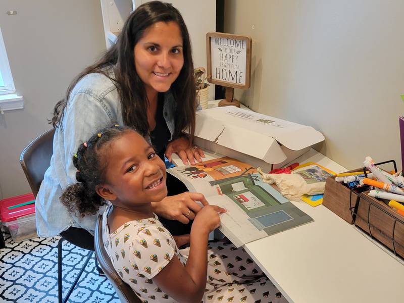 Pictured: Genoa resident Natalie Wylde and her daughter Tianna exploring the contents of a kindergarten readiness toolkit.