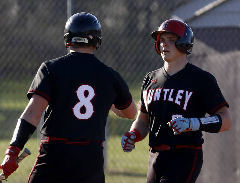 Huntley’s Brayden Bakes waits to give his brother, Ryan Bakes, a “high five” after he hit a home run during a Fox Valley Conference  baseball game against Huntley Wednesday, April 12, 2023, at Prairie Ridge High School. Brayden Bakes hit a home run right after his brother’s home run.