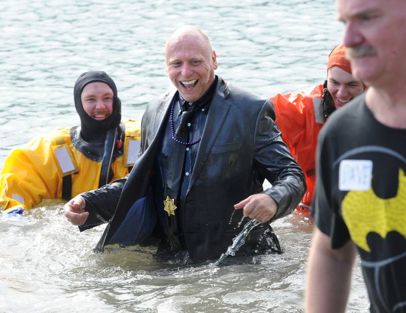 Representing the Oswego Police Department, a fully suited Scott Baker stands up after going under during the annual Polar Plunge to support Special Olympics Illinois at Siver Springs State Park's Loon Lake on Sunday, Mar. 5, 2023.