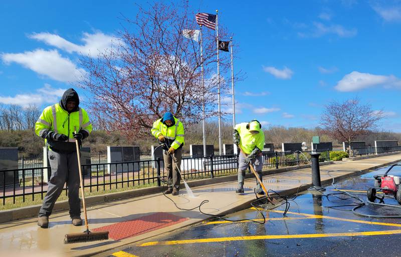 Laborers Local 393 volunteer Thomas Simon and Marcelis Edwards are joined by Marseilles volunteer David Raikes in sweeping out the Middle East Conflicts Memorial Wall on Wednesday in Marseilles.