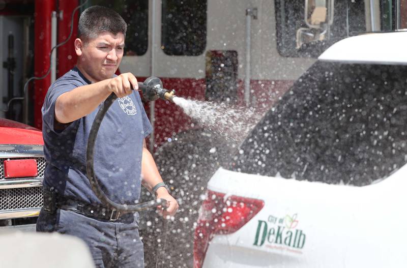 Juan Gaska, a firefighter paramedic with the DeKalb Fire Department, washes one of their vehicles Tuesday, May 16, 2023, at Fire Station 1 in DeKalb.